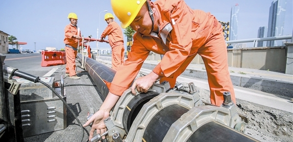 图为工人在进行天然气输气管道施工。